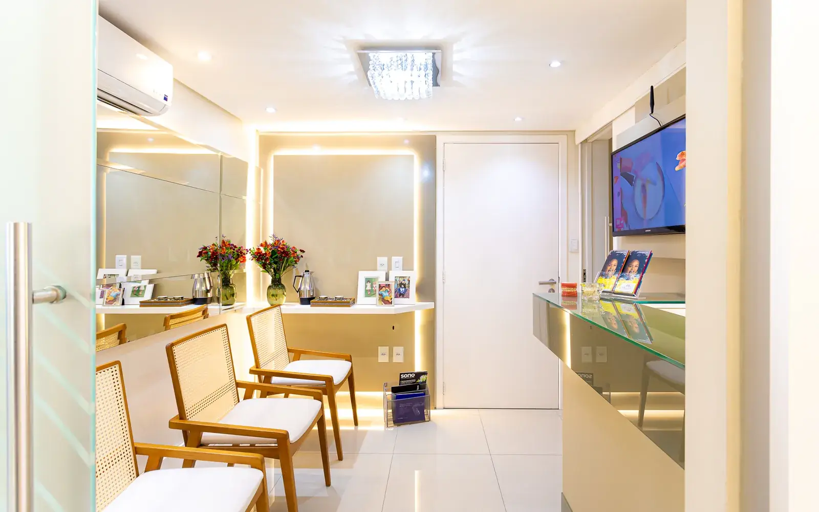 Sala de espera da Migliore Odontologia, com poltronas trançadas e iluminação quente